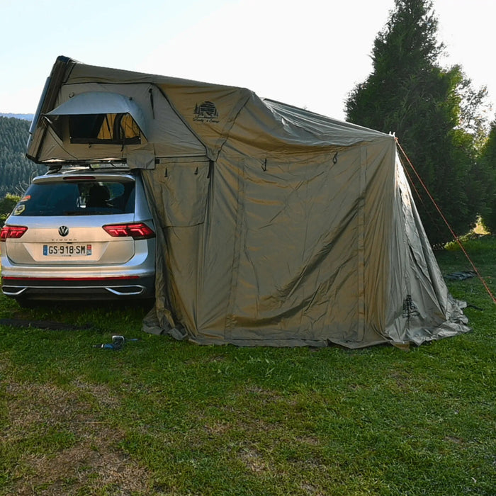 Voiture avec une tente de toit rigide installée, offrant un hébergement spacieux pour le camping pour 2 à 3 personnes en plein air.