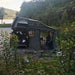Voiture avec une tente de toit installée en pleine nature, montrant un camping confortable pour 2-3 personnes près d'un lac et des montagnes.