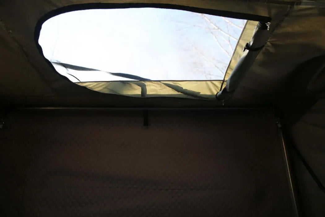 Vue intérieure d'une tente rigide de toit montrant le ciel ouvert et un tissu durable.